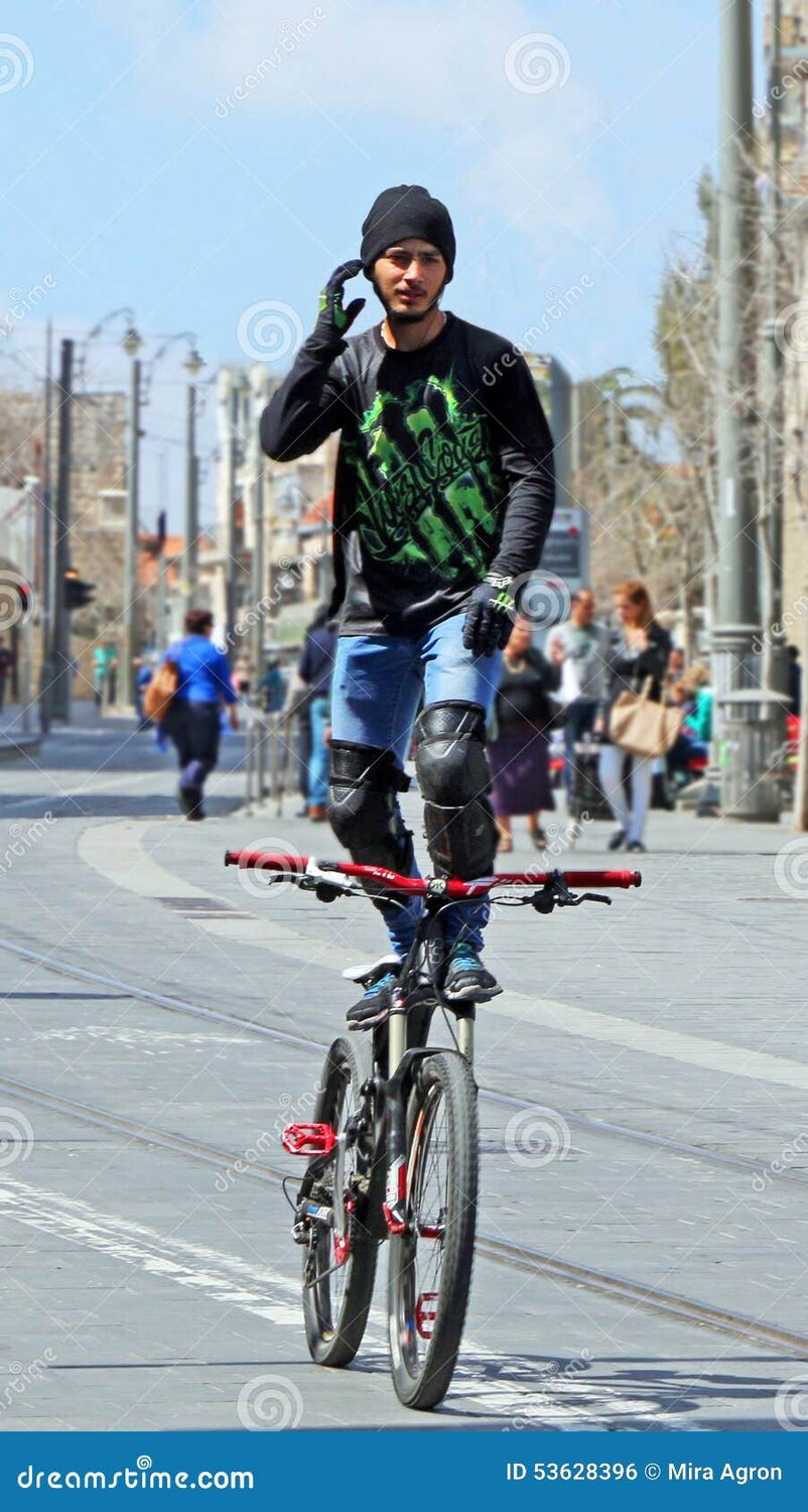 jerusalem-daredevil-stuntman-riding-his-bike-standing-top-his-seat-hands-free-jaffa-street-isr...jpg